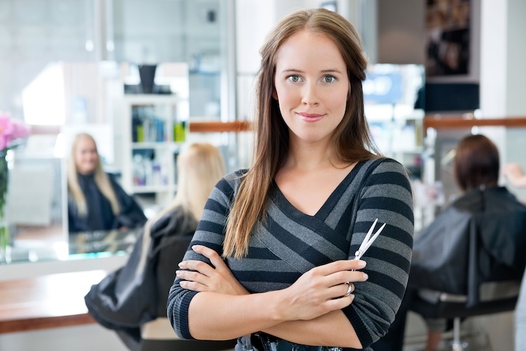 Woman with beautician insurance holding scissors