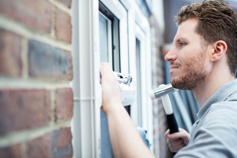 Contractor with public liability insurance hammering into a nail
