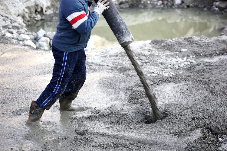 Man with concreters insurance pouring concrete