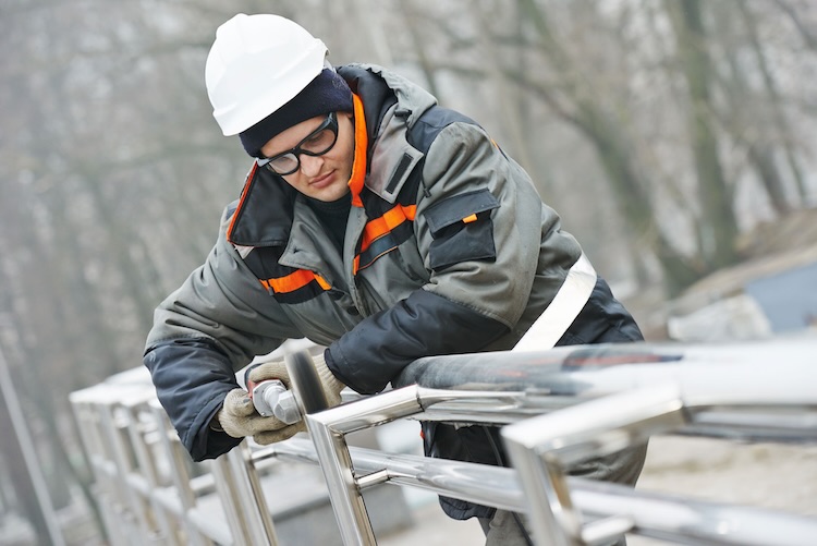 Man with fencers insurance installing fencing