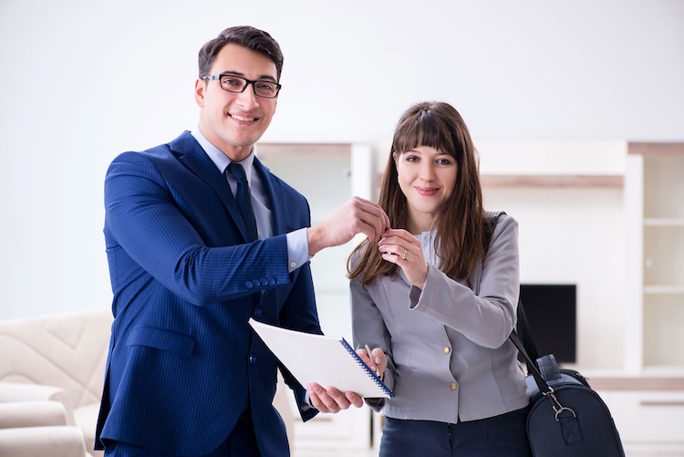 Man and woman with finance and mortgage brokers insurance holding a key