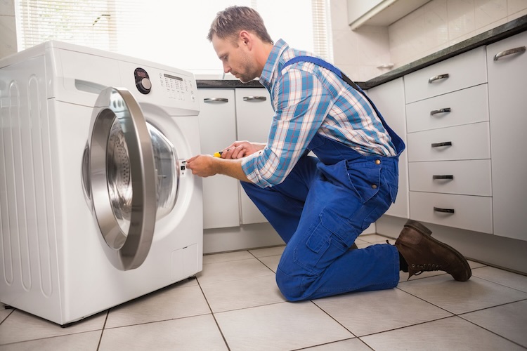 Man with handyman insurance fixing a washing machine