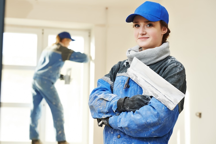 Woman with plasterers insurance holding plastering tools