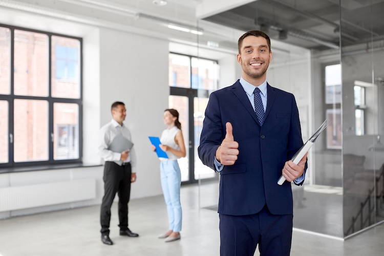 Man with real estate agents and landlords insurance wearing a suit and smiling