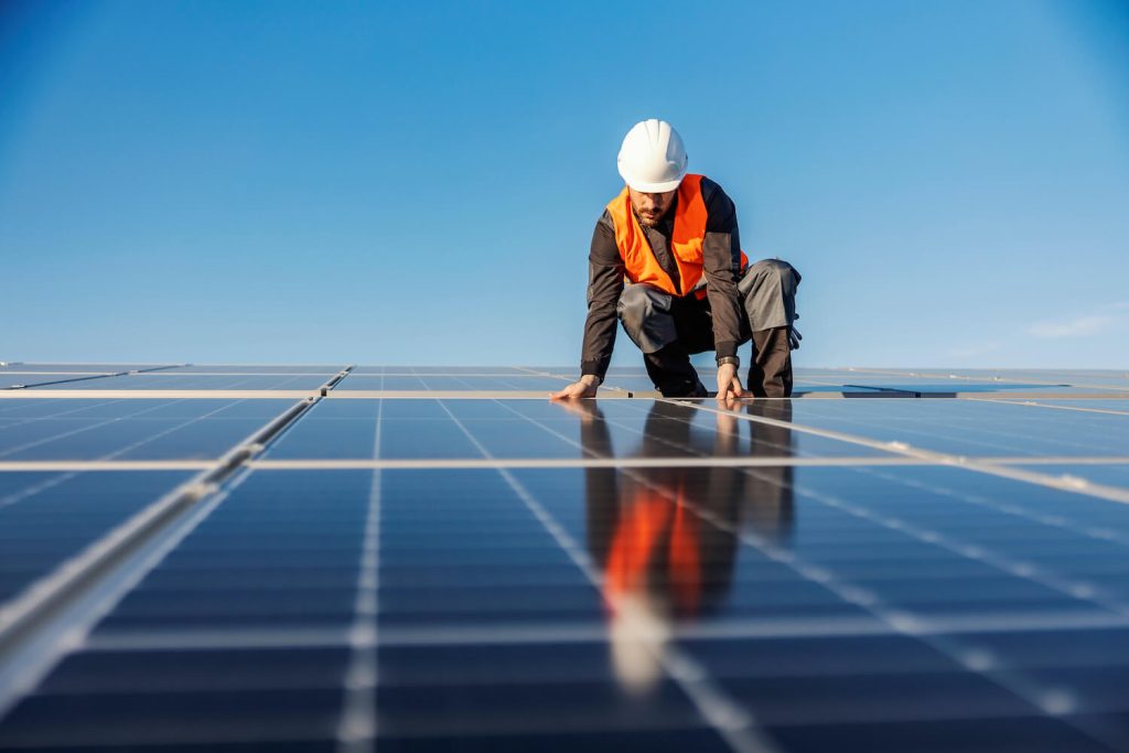 Man with solar panel installer insurance installing a solar panel