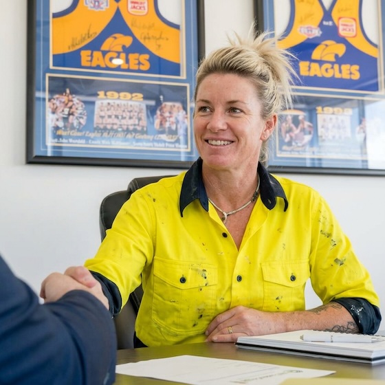 Female carpenter contractor shaking an insurance broker's hand